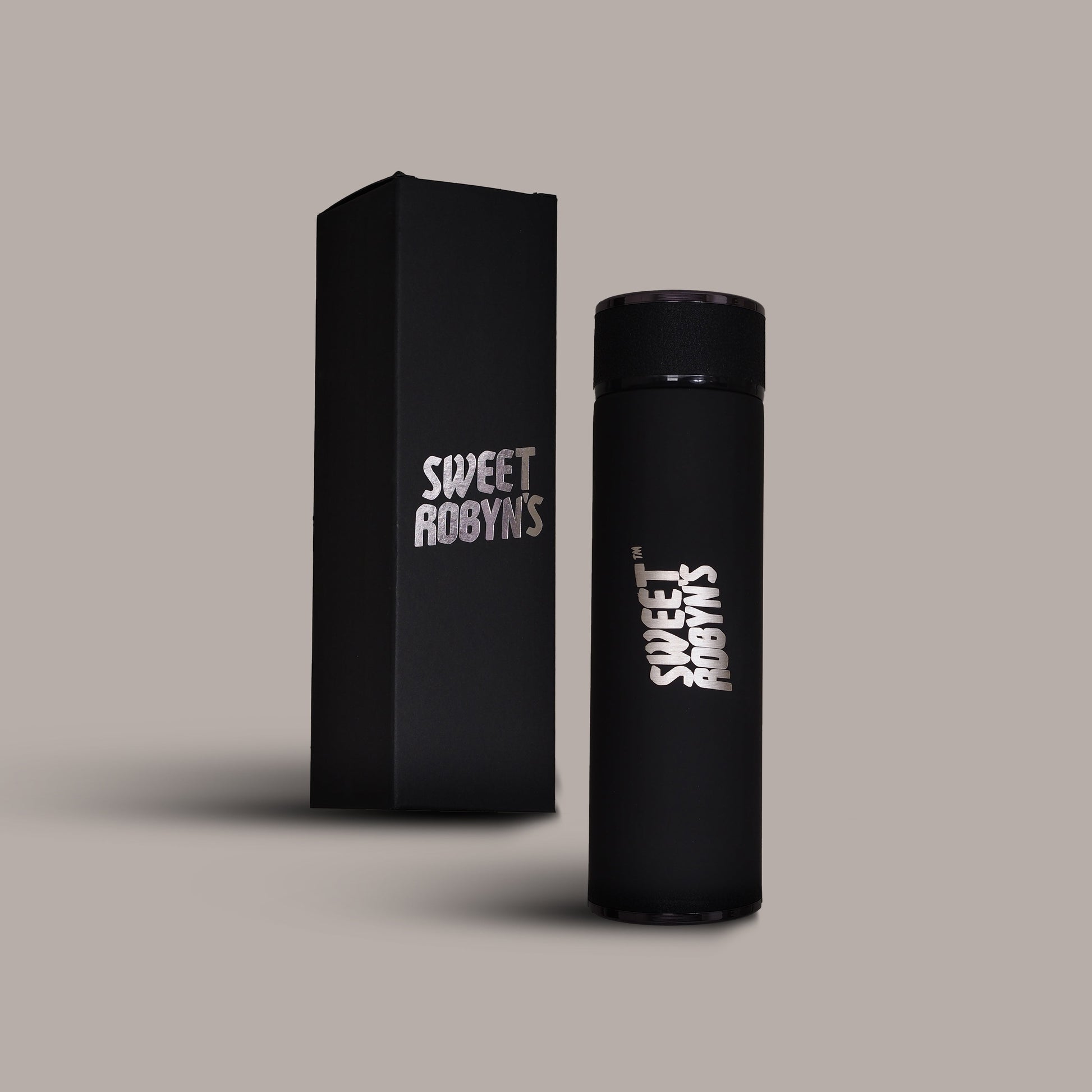 A black stainless steel flask with the brand name 'Sweet Robyns' printed on it, displayed next to its packaging box.
