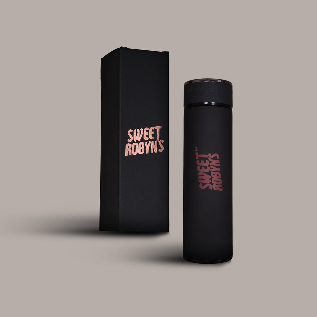A dark grey stainless steel flask with a rose gold font, accompanied by a black box with 'SWEET ROBYNS' branding.